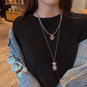 Double-layered silver necklace with rhinestone bear and LOVE pendant on a model