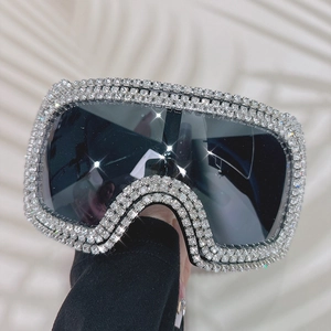 Close-up of oversized square sunglasses with sparkling rhinestones and dark lenses