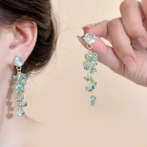 Detail of blue glass flower drop earrings with sheer fabric and cluster bead design