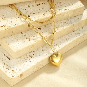 Detail view of gold layered paperclip chain necklace with a 3D heart pendant on stone