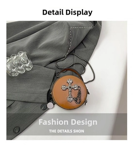 Detail showing retro gothic round mini crossbody bag with silver cross and metal chain