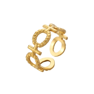 Macro detail of gold-plated XOXO cutout pattern on adjustable stainless steel ring