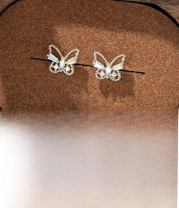 Macro detail of silver butterfly stud earrings with colorful zircon and size specs