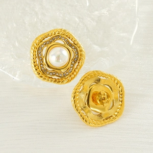 Vintage gold petal earrings with white pearl and rhinestones on silk background