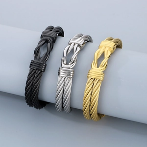 Detailed view of woven stainless steel wire bracelets in black, gold, and silver finishes