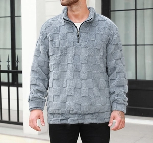 Détail d'un sweat-shirt gris pour homme avec texture en damier et col demi-zippé