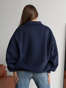 Detail view of the back of a navy blue oversized hoodie featuring a dropped shoulder design