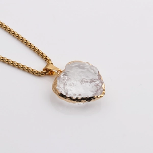 Detail shot of crystal moon heart pendant with gold plating on a white background