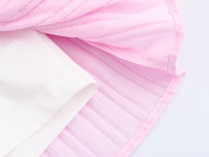 Detailed view of layered pink textured fabric and white lining on this tiered mini skirt