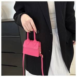 Detailansicht einer rosa Mini-Umhängetasche mit elegantem Griff und verstellbarem Riemen