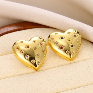 Macro shot of gold heart studs featuring multi-colored star-set cubic zirconia stones
