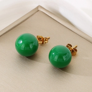Detailed view of emerald green crystal stud earrings with gold-plated titanium butterfly backs