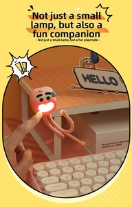 Pink cartoon octopus night light with flexible legs attached to a desk edge
