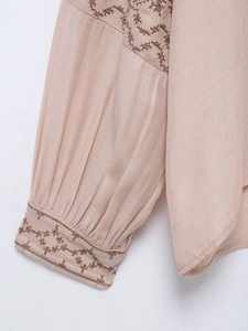 Detailed view of the embroidered cuff and pleated shoulder of this vintage linen shirt