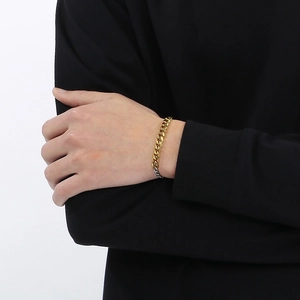 Close-up of a gold Cuban link bracelet featuring a bold two-tone textured metal design