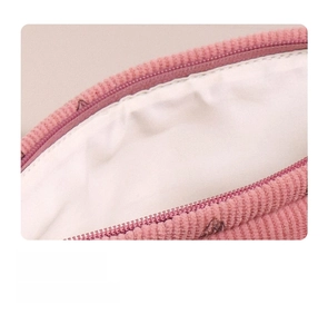 Detail showing neat stitching and soft corduroy texture of the pink makeup bag