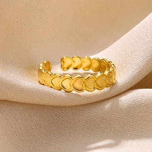 Macro detail of gold adjustable heart ring on beige satin fabric with luxury lighting