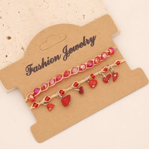 Detail of red bohemian hand-woven bracelets with faceted beads and natural stone on cards
