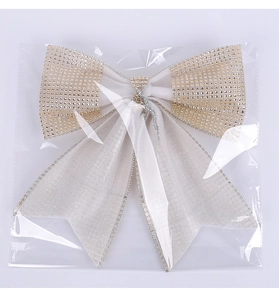 Sparkly silver Christmas bow with gold rhinestones packaged in a clear protective OPP bag