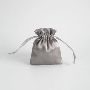 Close-up of grey satin drawstring pouch with silky texture for jewelry gift storage