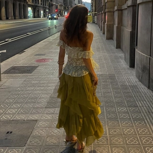 Detail of white lace off-shoulder top and layered olive green ruffle maxi skirt ensemble