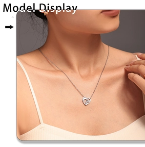 Détail d'un collier avec pendentif cœur argenté et motif soleil sur le mannequin