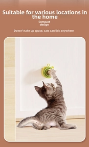 Catnip ball toy with adhesive base shown with a grey kitten playing on a wall