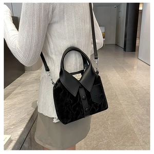 Detail of trendy black shirt-style handbag with button collar design and texture