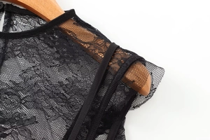 Close-up detail of delicate black lace pattern on the shoulder of a sexy women top