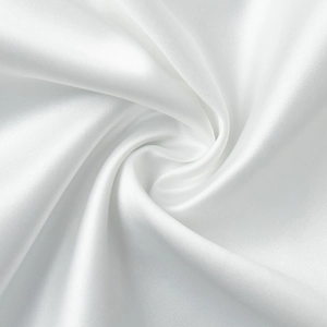 Gros plan du tissu en satin blanc avec des plis en spirale et un éclat soyeux
