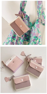 Macro detail of macaron color block mini wallet with heart zipper pendant and snap closure