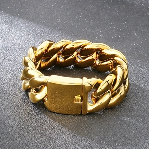 Detail view of 25mm gold Cuban link bracelet with box clasp on dark stone surface