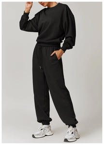 Vue latérale de femme en survêtement noir avec sweat-shirt et pantalon de jogging