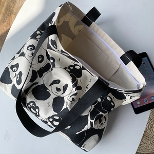 Detail view of large canvas panda tote bag showing top zipper closure and internal pocket