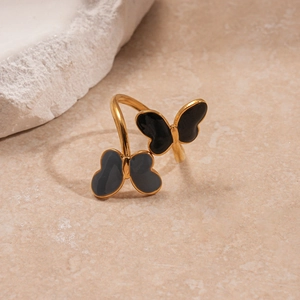 Close-up of golden open ring featuring two-tone black and grey butterfly designs