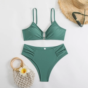 Detailed flat lay of sage green bikini set with gold ring hardware and ruched high waist