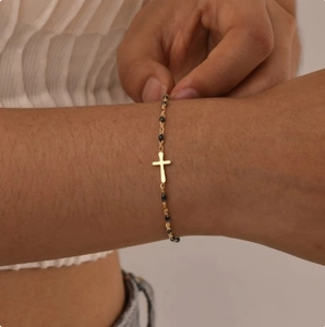 Chic gold stainless steel bracelet with black beads and a centered cross pendant