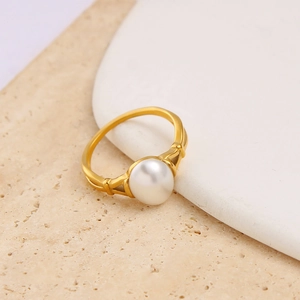 Macro di una perla bianca incastonata in un anello d'acciaio inossidabile dorato 18K