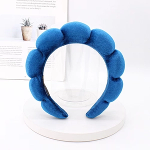 Close-up of blue velvet padded headband with segment bubble design on a display stand