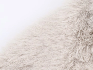 Detailopname van de beige imitatiebont textuur met hoge dichtheid op een modieuze ritsjas