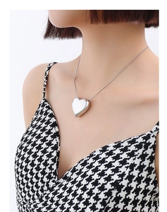 Detail of silver heart pendant necklace on model with polished snake chain and mirror finish