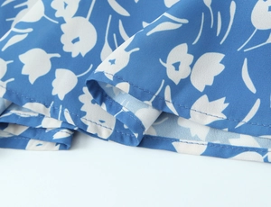 Gros plan de l'ourlet de robe fleurie bleu ciel avec des coutures doubles professionnelles