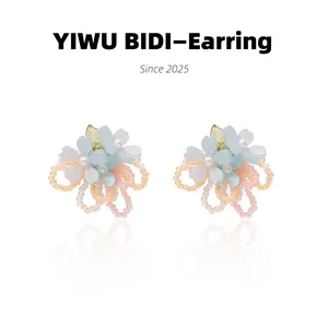 Detailed macro view of handmade blue floral earrings with pink beaded ring tassels