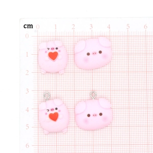 Pink resin cartoon pig charms with hearts on centimeter grid scale board