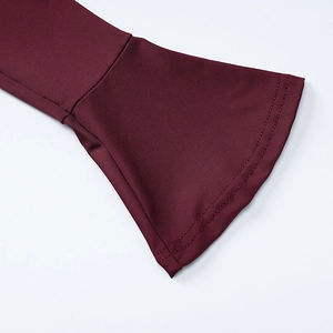 Close-up of elegant flared cuffs on a wine red long-sleeved dress with fine stitching