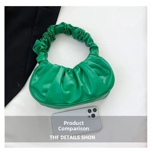 Detail of green ruched cloud bag showing vibrant PU leather texture and pleats