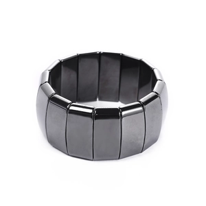 Polished magnetic black hematite wide link bracelet for men on a white background