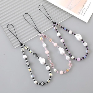 Detailed shot of handmade beaded phone lanyards in black, pink, and purple crystal beads