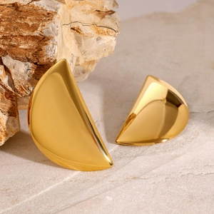 Polished gold crescent moon earrings displayed on a natural textured stone base