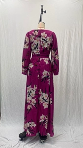 Détail d'une robe longue à fleurs violettes avec col en V, manches longues et taille haute